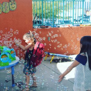 Image of a young girl playing in bubbles at the back to school fair
