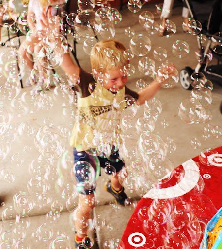 small child playing in bubbles at Children's Clinics Play Group