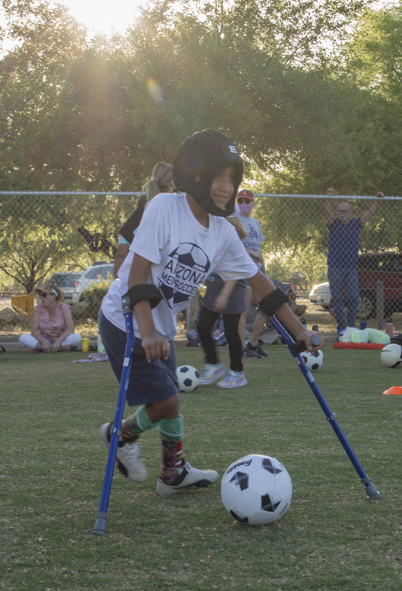 Boy playing soccer while using assistive devices for his legs